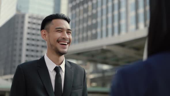 Asian businessman in a black suit talking with client partnership deal at a business.