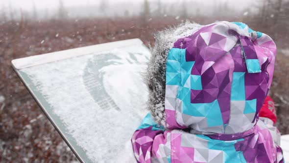 little girl wipes snow off trail sign snowstorm slomo super cute