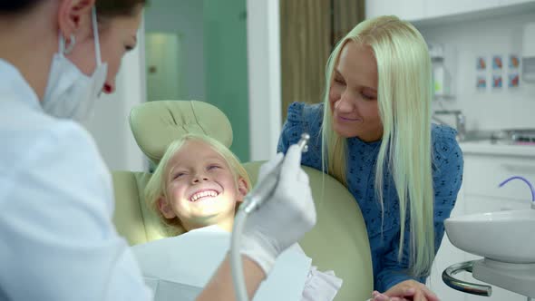 Dentist Shows a Medical Drill, a Girl Laughs