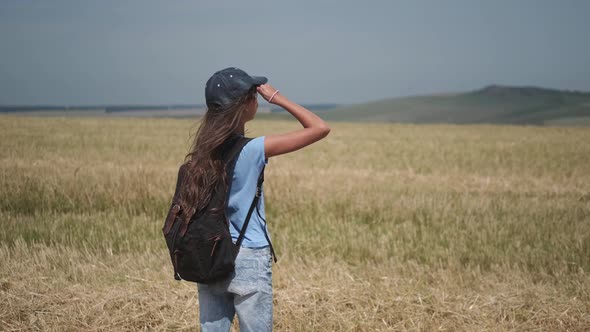 Child Traveler Looks Into the Distance. a Little Girl with a Backpack Went Camping