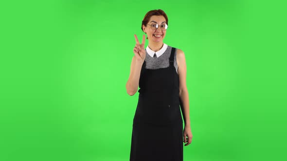 Funny Girl in Round Glasses Is Showing Two Fingers Victory Gesture, Green Screen