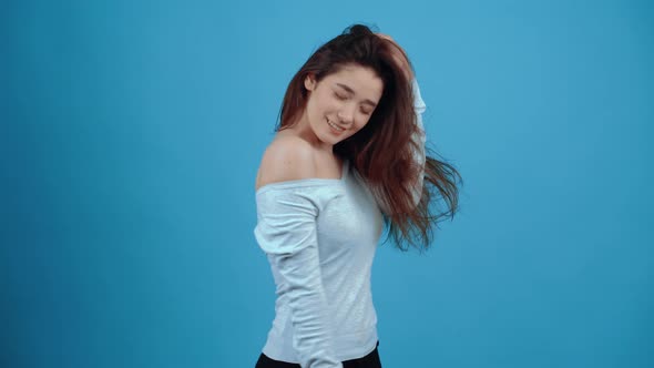Happy Young Woman Smiling While Arranging Her Hair
