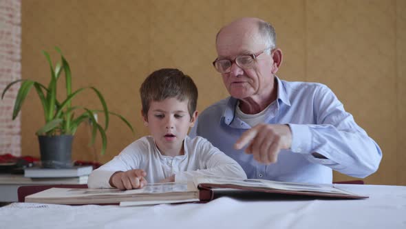 Old Elderly Man in Glasses for Vision Together with His Grandson Enjoy Happy Memories Watching a