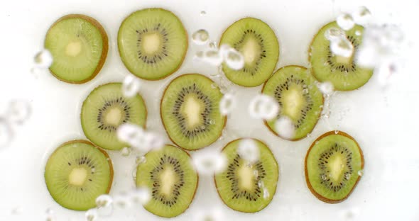 On a White Background, Sliced Kiwis Are Sprinkled with Water. Water Drops Juicy Kiwi