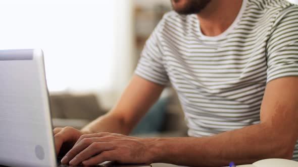 Man in Headphones with Laptop Working at Home