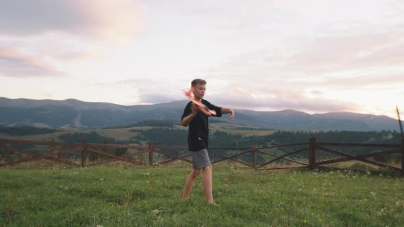 Boy Playing with Toy Aircraft in Countryside