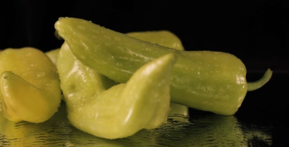 Wet Green Peppers Rotating On Black