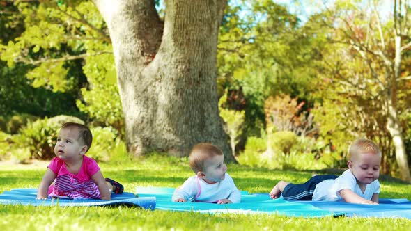 Three babies lying on exercise mat