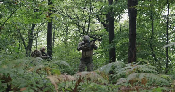 Millitary Operation with Gorup of Soliders Attacking Enemy Line in Dense Forest During Day Time