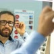 Bearded man is choosing eyesight glasses at optics store - VideoHive Item for Sale