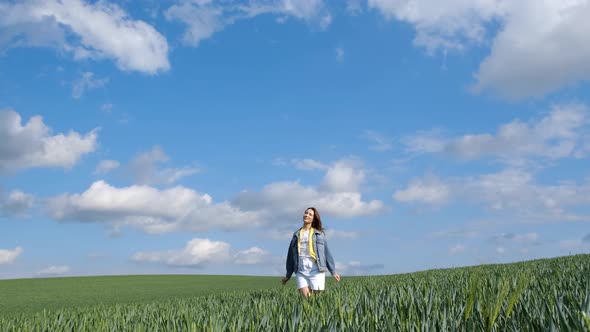 Attractive Woman Spreads Her Arms in Slow Motion in the Middle of a Green Field