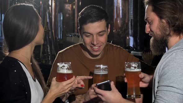 Group of Friends Having Fun at Beer Pub, Using Smart Phone Together