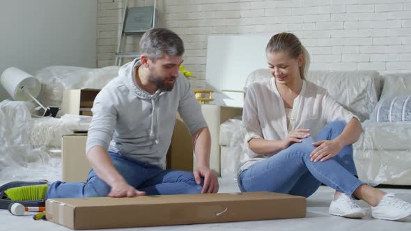 Couple Opening Cardboard Box