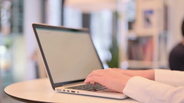 Close Up Woman Typing on Laptop Keypad in Cafe