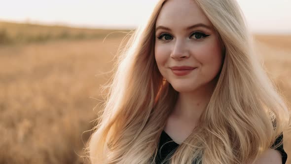 Portrait of a Blonde Girl in a in Wheat Field on Summer Day