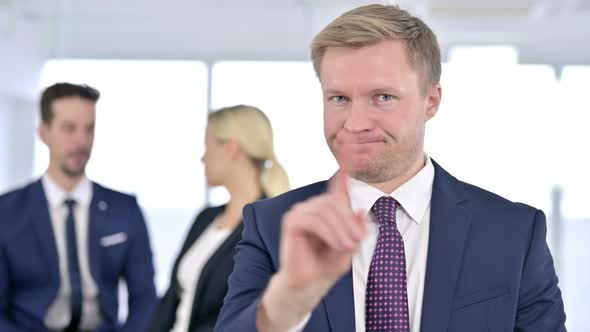 Portrait of Serious Businessman Saying No By Finger Sign 