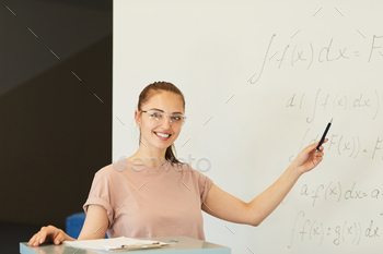 lasses pointing at math formula while explaining solution at class
