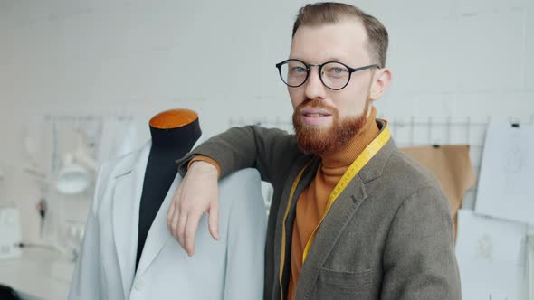 Talented Young Tailor Standing in Studio Next to Dummy Smiling Looking at Camera