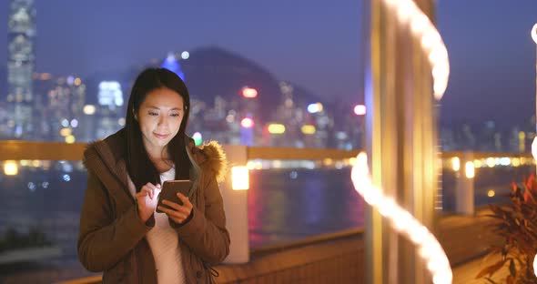 Woman Use of Smart Phone in The City at Night, Urban Cityscape Background of Hong Kong