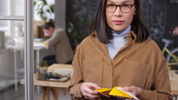 Female Designer Looking at Color Swatches and Smiling for Camera