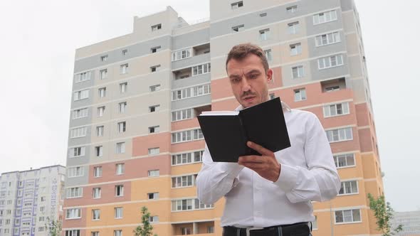 Nervous Businessman in a White Shirt Looking Through Records Embezzlement