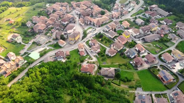 Aerial pan up to reveal a small historic town in the Italian Alps
