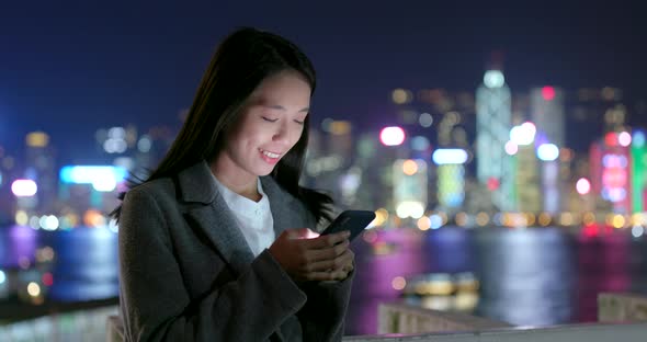 Business woman use of smart phone in city at night