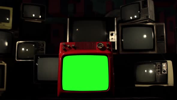 Old Red TV with Green Screen in the Middle of Many Retro TVs. Dolly In.