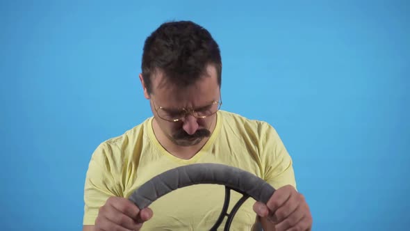 Funny Man Gets Into an Accident and Bangs His Head on the Steering Wheel on a Blue Background Slow