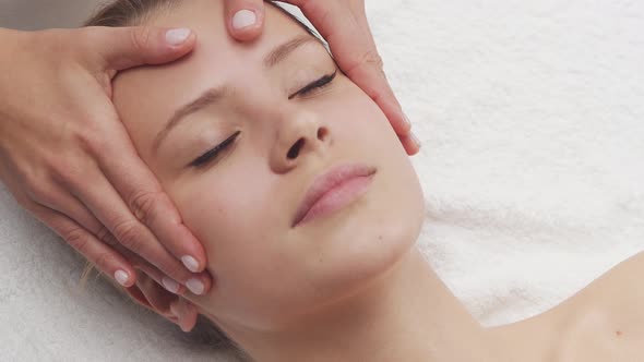 Young, healthy and beautiful woman gets massage therapy in the spa salon.