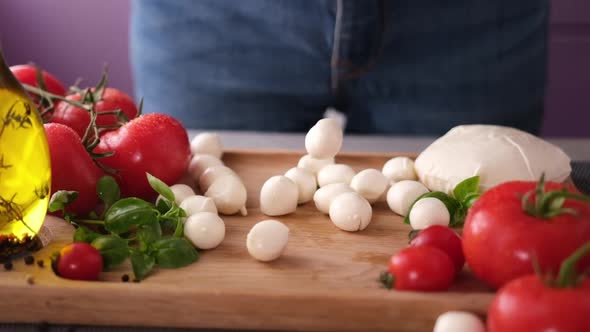 Mozzarella Cheese Small Balls Falling on Wooden Cutting Board