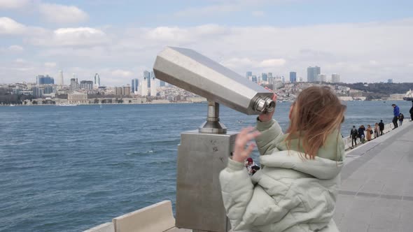 Traveler Woman Looking City Panorama By Tourist Binoculars to Bosporus Strait in Istanbul Turkey