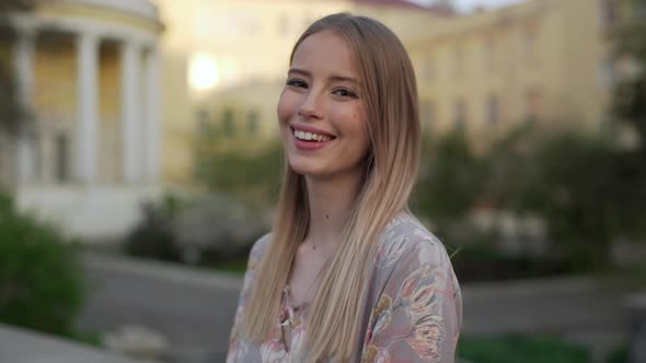 Portrait Closeup of Attractive Young Woman Wearing Dress Smiling While Standing on City Street