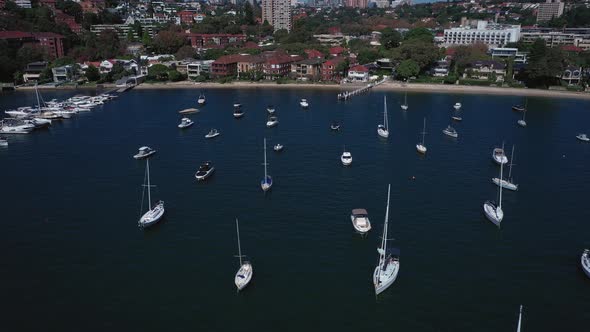 Sydney Harbor on a beautiful sunny day from Double Bay featuring boats, blue sky and water. Drone tr