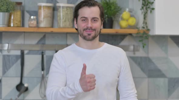 Young Man Showing Thumbs Up in Kitchen