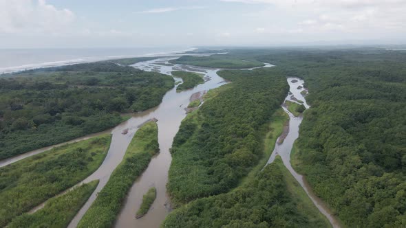 Costa Rica wetlands at the central pacific coast underneath a blue and cloudy sky. Wide angle aerial