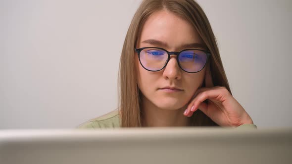 Portrait of focused woman in glasses browsing