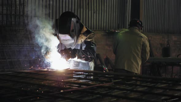 Worker Welds Steel Rods on the Manufacturing