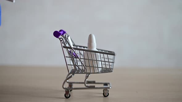 The Pharmacist in the Seals Fills a Mini Shopping Cart with Various Medicines for a Viral