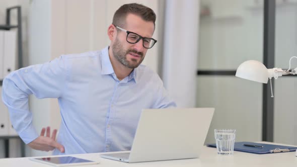 Middle Aged Man Having Back Pain While Working on Laptop