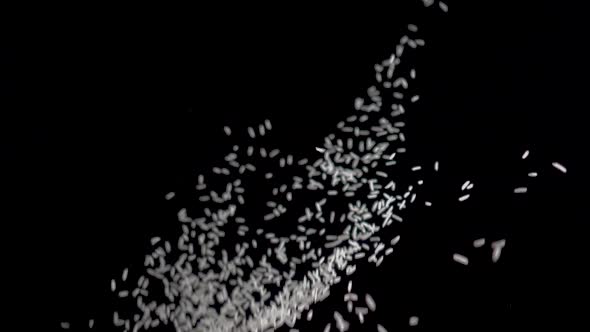 White Rice Flies Up on a Black Background. Slow Motion Video. Food Video White Rice