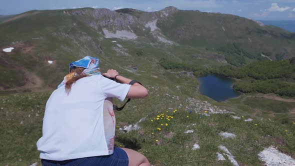 Woman photographs nature in the mountains in Montenegro. Female back tourist travel in Europe