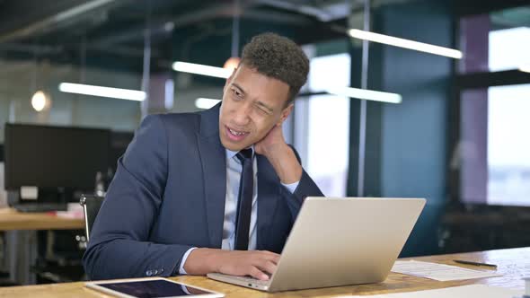 Hardworking Young Businessman Having Neck Pain in Office