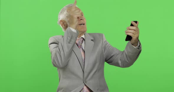 Handsome Elderly Businessman Having Video Chat Using Smartphone. Chroma Key