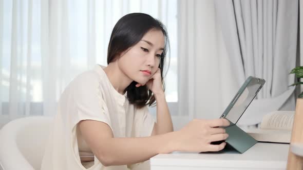 A smart freelance woman typing a promotional message on her website through a tablet she worries abo