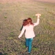 The Girl Runs Across the Field Holding a Plane Simulates Flight - VideoHive Item for Sale
