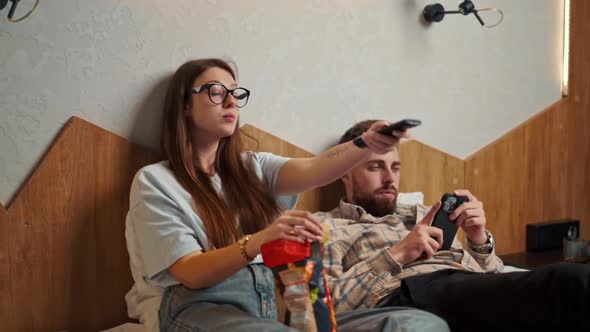 young couple watching TV in hotel room