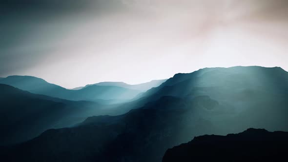 Black Rocky Mountain Silhouette in Deep Fog