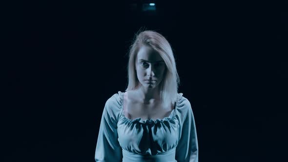 Serious Woman Portrait on Dark Background. Serious Looking Young Woman Portrait. Portrait of Sad or