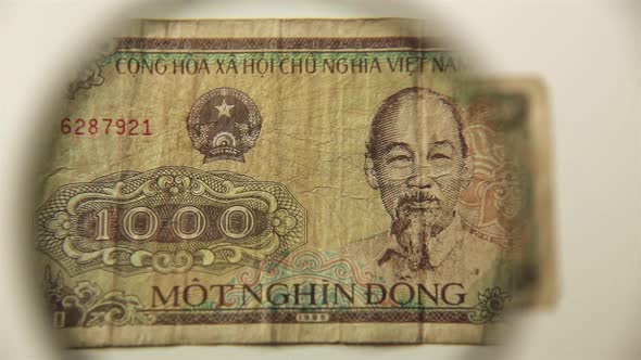 One thousand Vietnamese Dong and a magnifying glass.